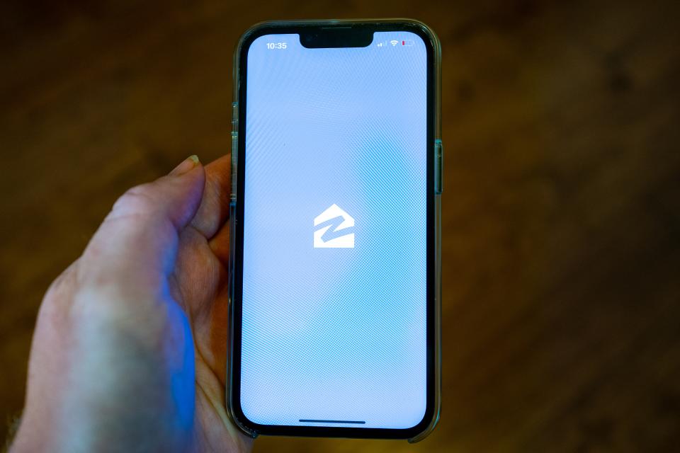 A hand holds an iPhone and uses the Zillow app, Lafayette, California, July 12, 2024. (Photo by Smith Collection/Gado/Getty Images)