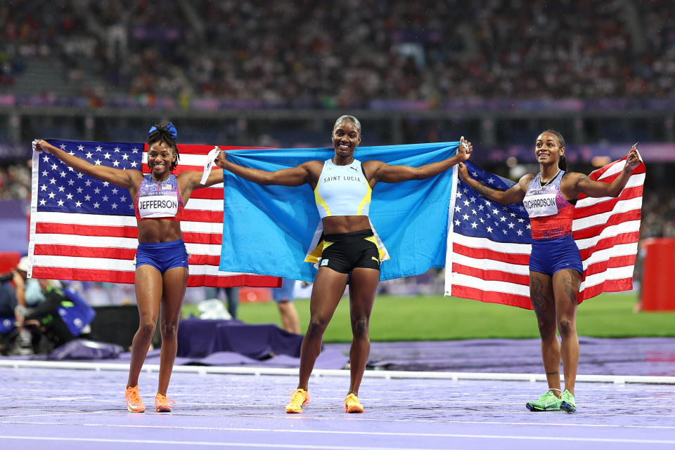 PARIS, FRANCE - AUGUST 03: Gold medalist Julien Alfred (C) of Team Saint Lucia, silver medalist Sha'Carri Richardson (R) of Team United States and bronze medalist Melissa Jefferson (L) of Team United States are celebrate after the competition on Day 8 of the Paris 2024 Olympic Games at the Stade de France on August 03, 2024 in Paris, France.  (Photo by Cameron Spencer/Getty Images)