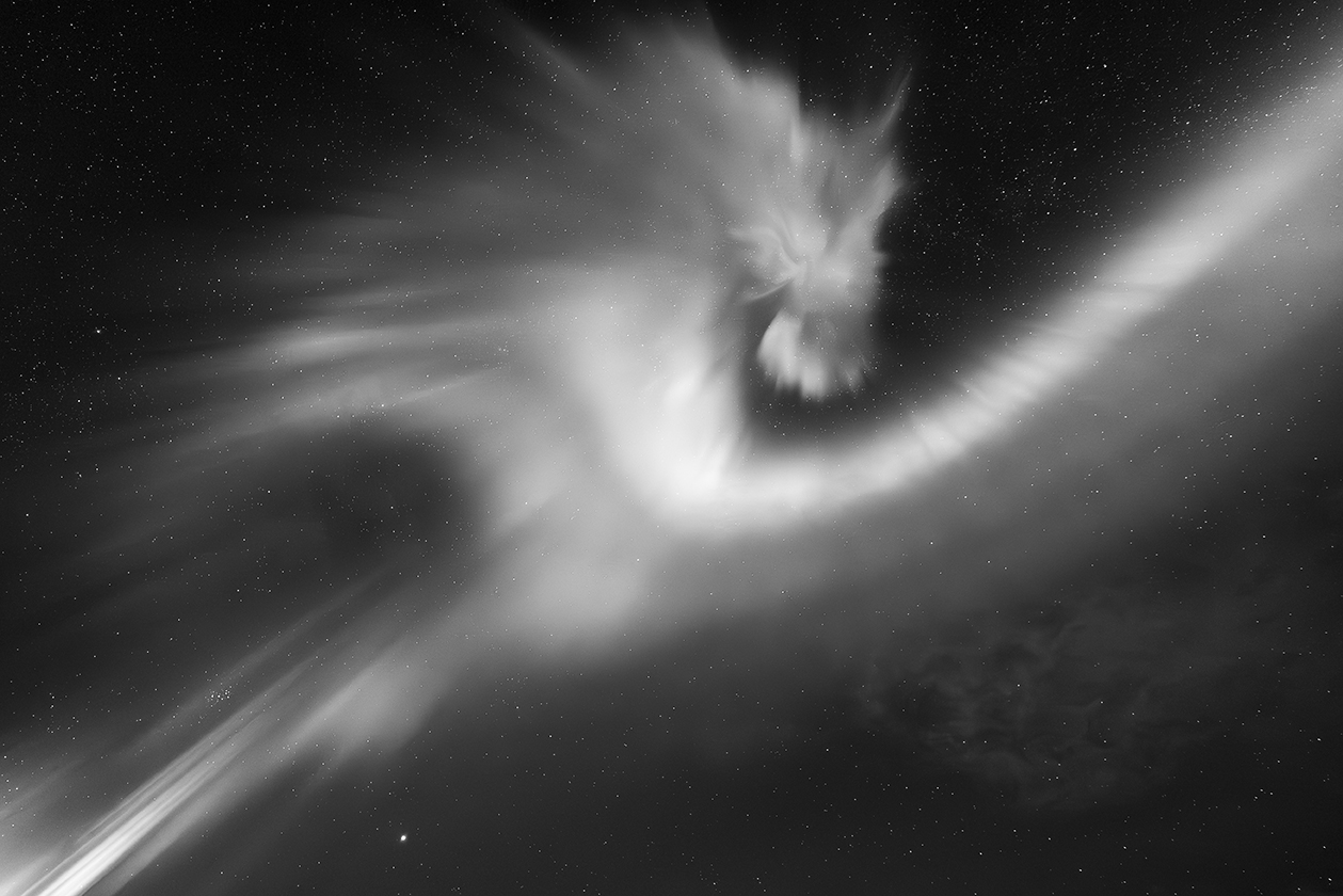 a rolling aurora shaped like a dragon's head looking back