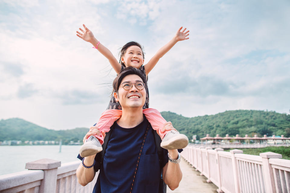 The lovely little girl raised her arms, looking up at the sky happily as her father carried her on his shoulders and walked away.