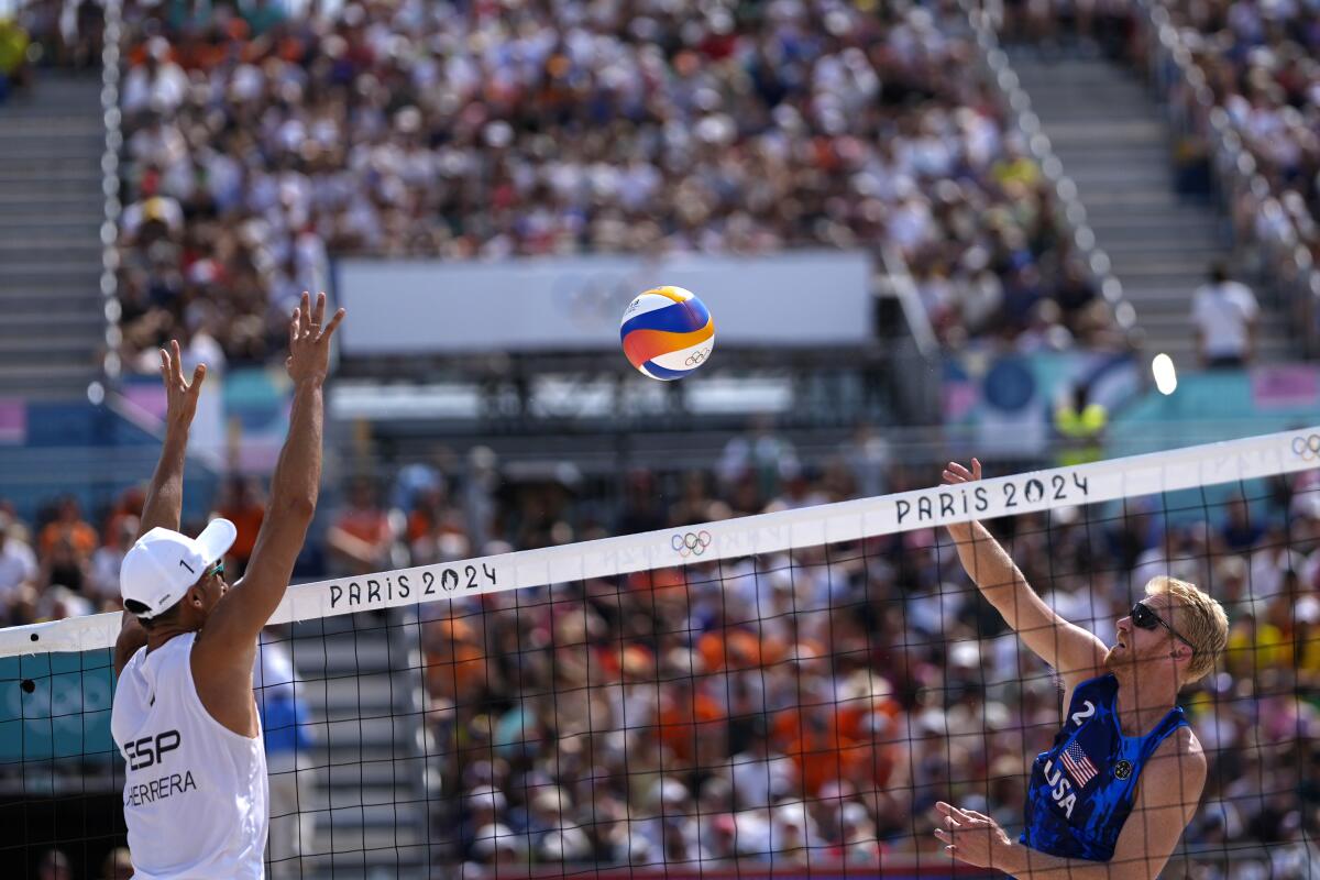 Chase Budinger, right, hits the net against Spain's Pablo Herrera Allepuz in a beach volleyball match Friday.