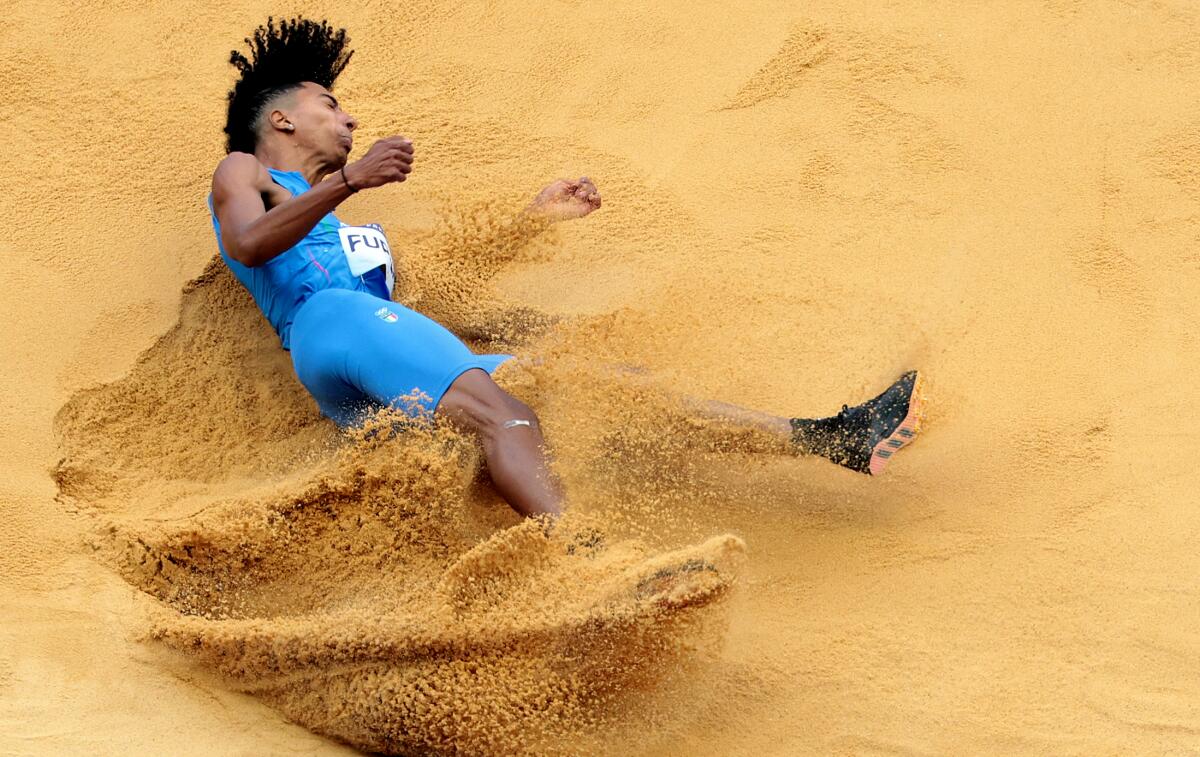 Italy's Matt Furlani lands in the sand pit during the men's long jump.