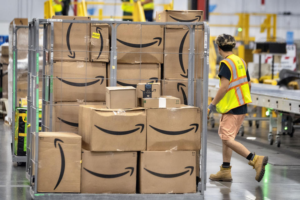 An Amazon employee passes Amazon packages through a cart on the floor at the Amazon DAX7 station during the annual Amazon Prime Day event on Tuesday, July 16, 2024, in South Gate, Calif.  (AP Photo/Richard Vogel)