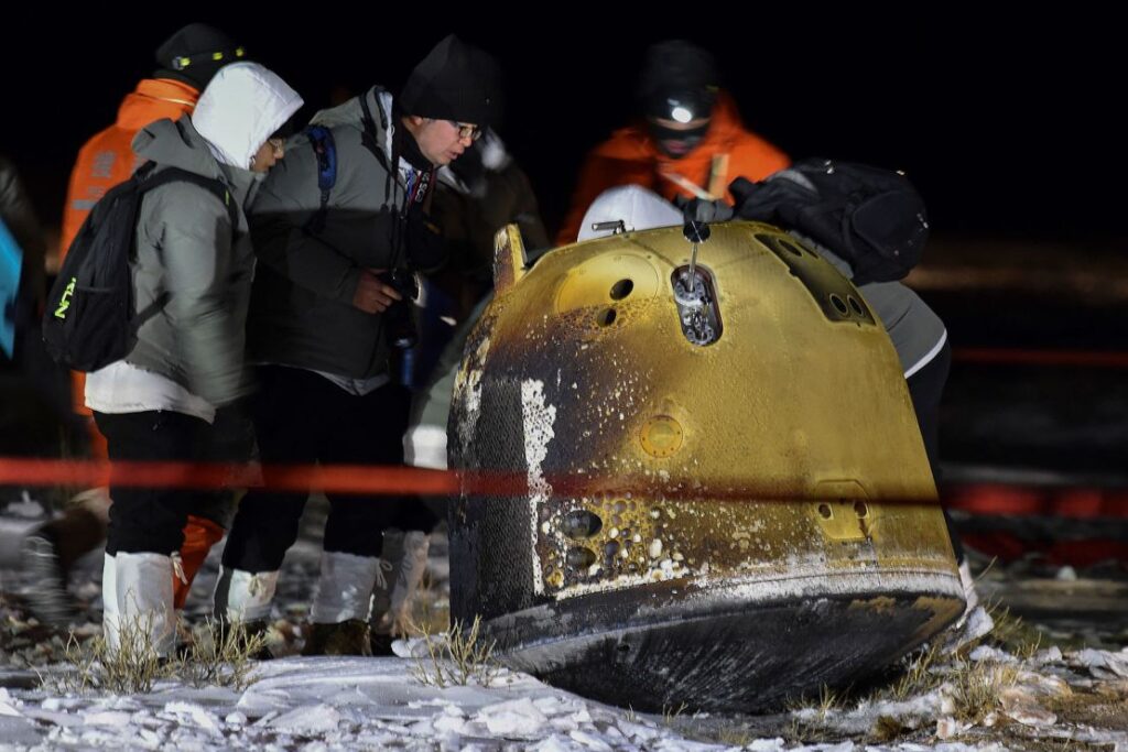 Rescue crew members inspect the probe of Chang'e 5 after it successfully landed in northern China in December 2020.