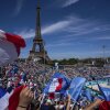 French fans wave flags during the women's beach volleyball match between Germany and France at the Eiffel Tower on Sunday.