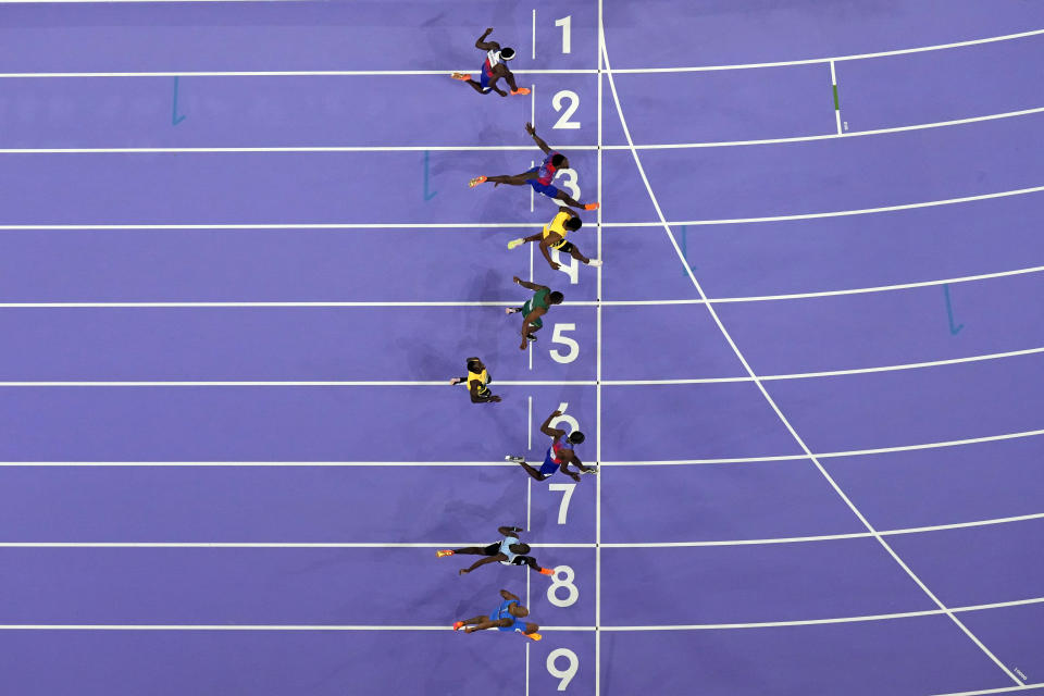 Noah Lyles, of the United States, row seven, wins the men's 100 meters final at the 2024 Summer Olympics, on Sunday, Aug.  4, 2024, Saint-Denis, France.  (AP Photo/David J. Phillip)