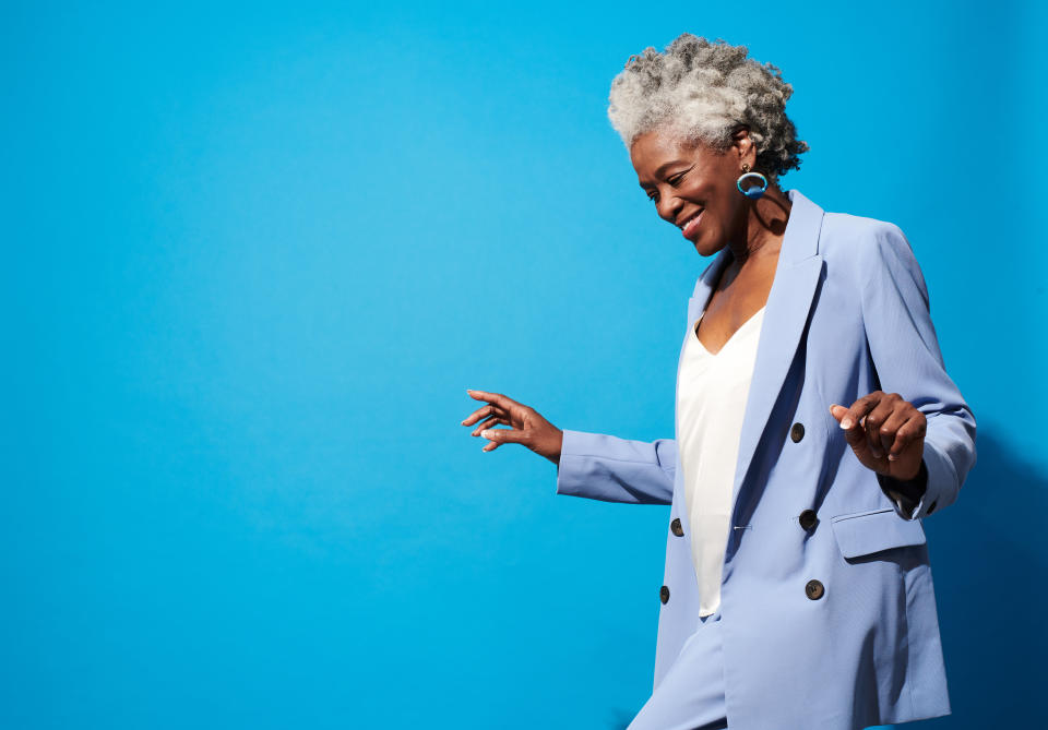 Close-up portrait of a beautiful senior woman against a blue background