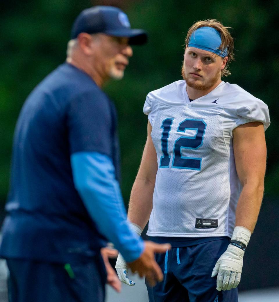 North Carolina sophomore defensive lineman Beau Atkinson (12) listens to coach Ted Monachino during the Tar Heels' first practice of the season Monday, July 29, 2024 in Chapel Hill, NC.